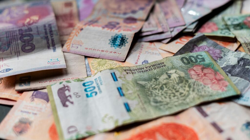 A detailed image showcasing various Argentine peso banknotes in vivid colors.